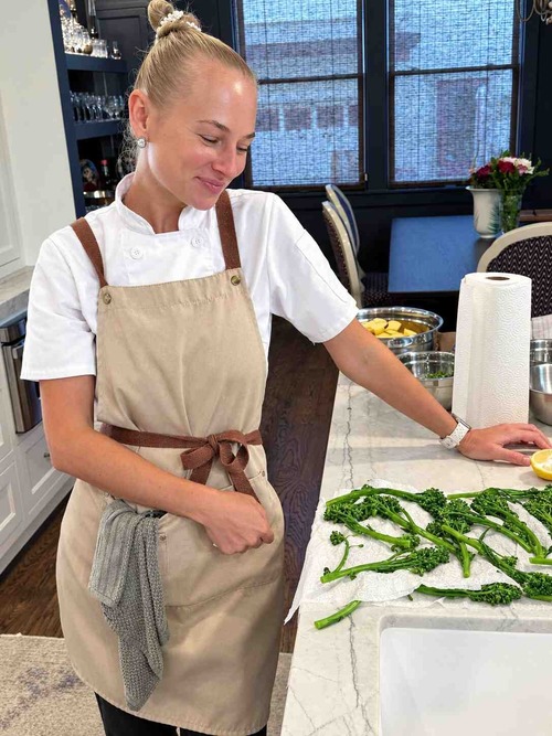 Chef Ana preparing asparagus in a kitchen.