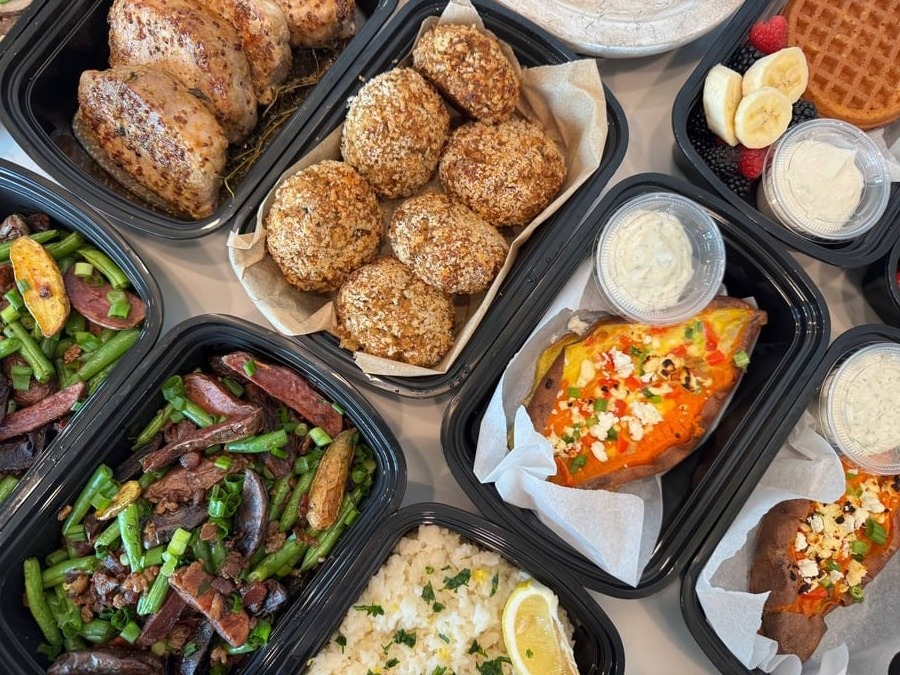 A complete spread showing scrambled egg-stuffed sweet potatoes, crab cakes, honey glazed pork chops, and classic bacon-dill green beans.