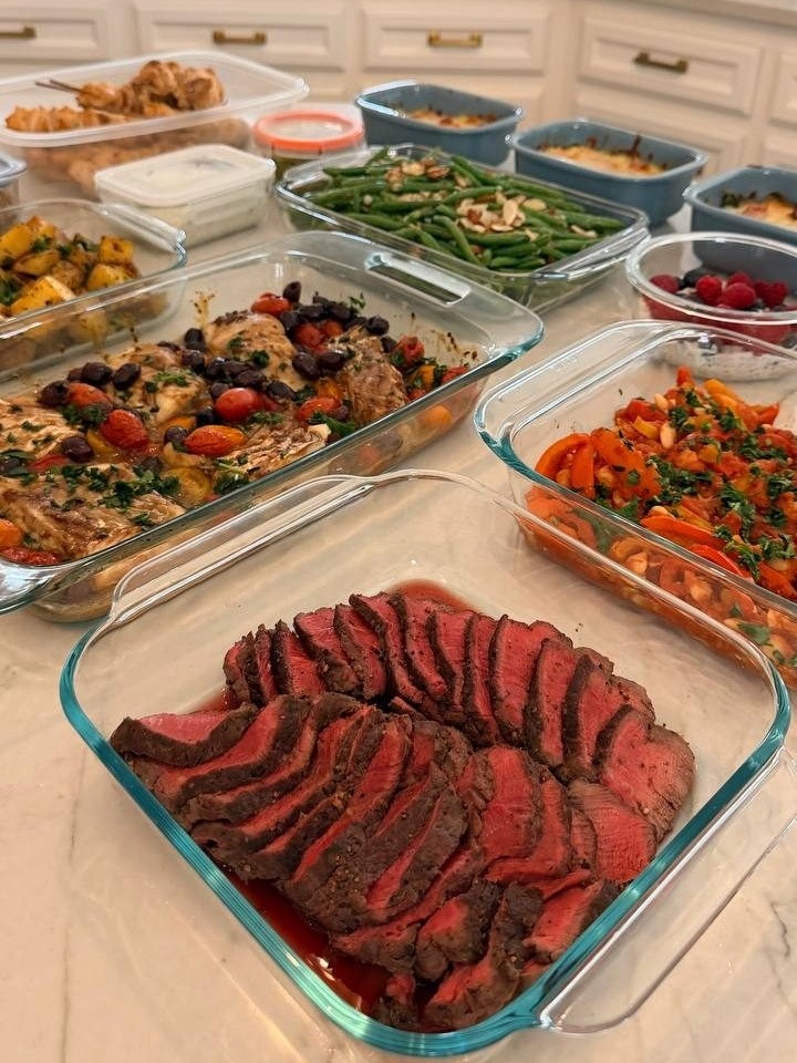 table filled with various dishes, including a large tray of meat