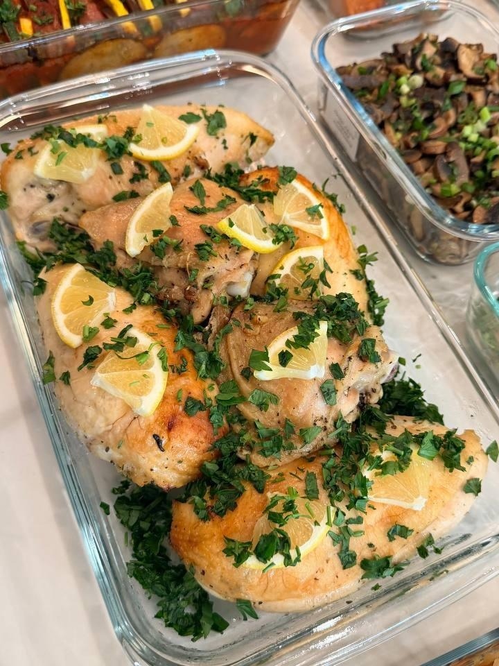 dish of chicken with lemon slices and herbs