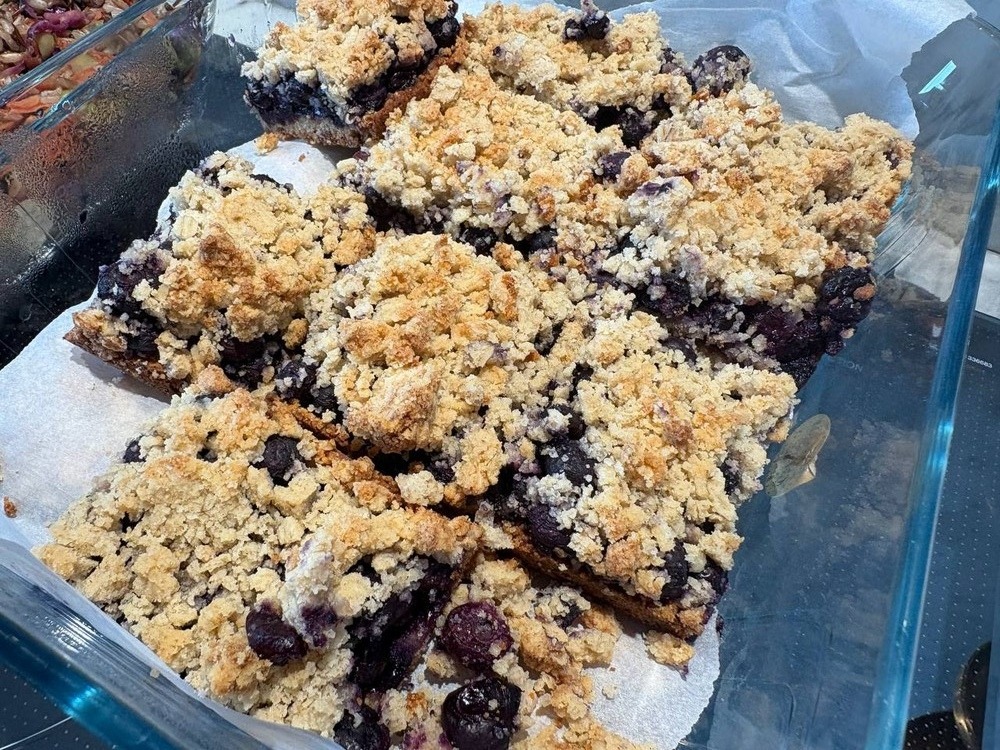 Close-up of blueberry crumble bars in a glass dish.