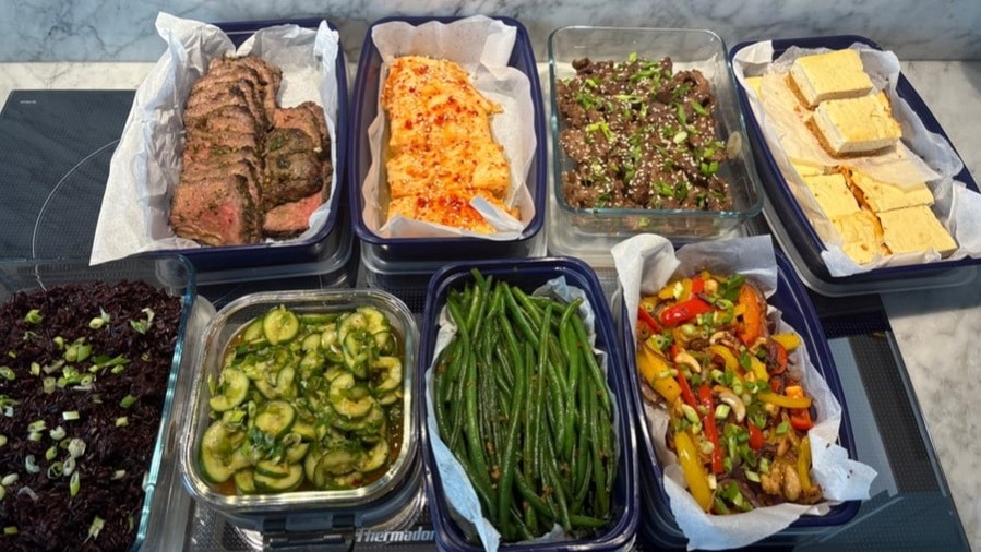Assortment of prepped Asian-inspired meals in containers on a counter.