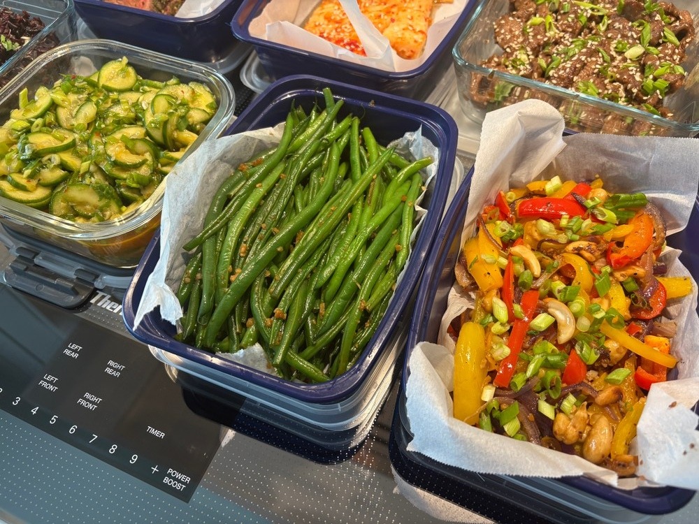 Green beans and colorful bell pepper stir-fry in meal prep containers.