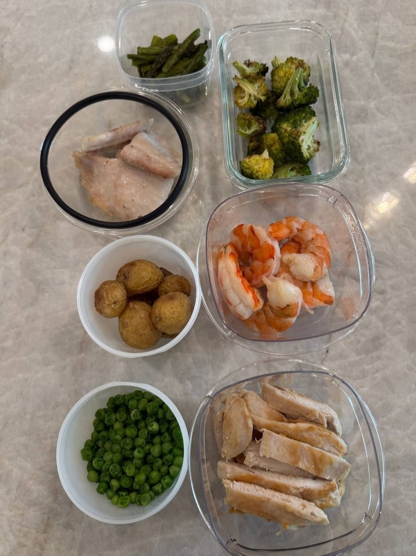 A child's portions laid out plain: sliced chicken, peeled shrimp, baby potatoes, peas, broccoli and asparagus.