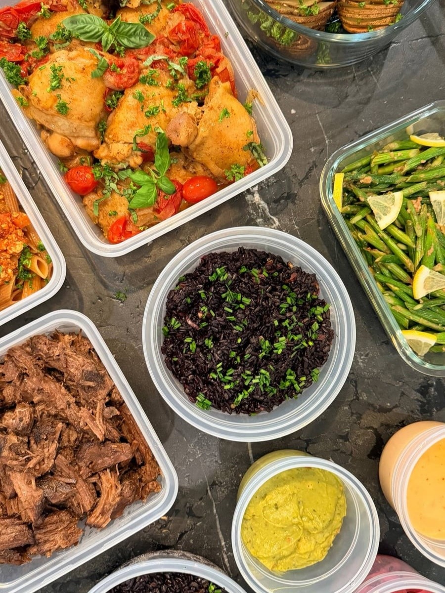 Mexican shredded beef pulls apart in long strands beside black rice, guacamole and a jar of pink pickled onion.