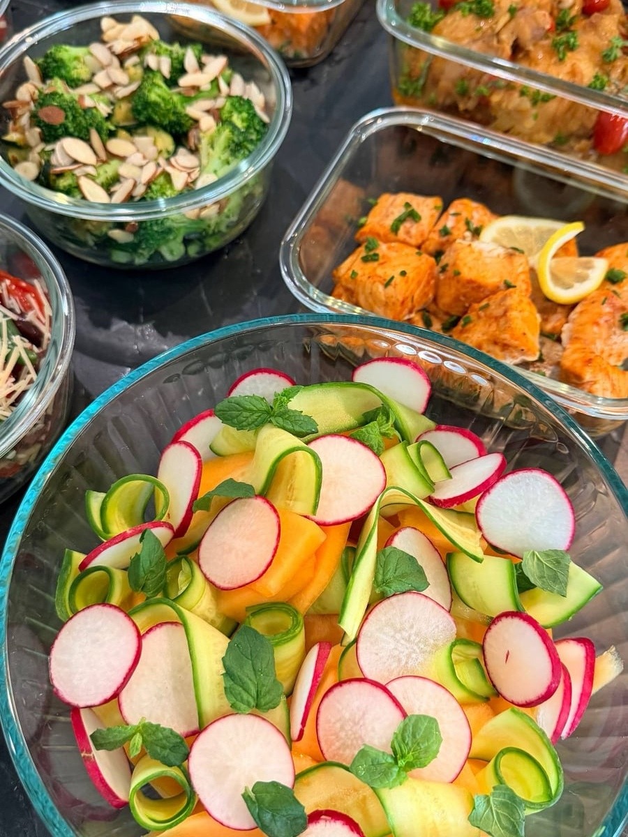 Cantaloupe wedges, cucumber ribbons and thin radish rounds layered with mint leaves in a wide bowl.