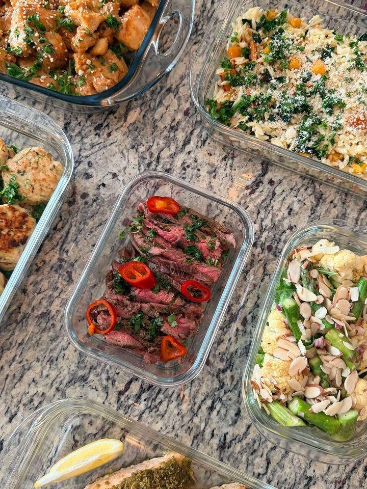 A collection of glass meal prep containers showcasing vibrant crispy orange chicken, sliced Vietnamese steak, turkey fritters, and vegetable-rich grains.