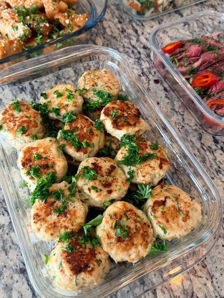 Golden-brown zucchini turkey fritters garnished with fresh herbs alongside orange glazed chicken and healthy rice orzo.