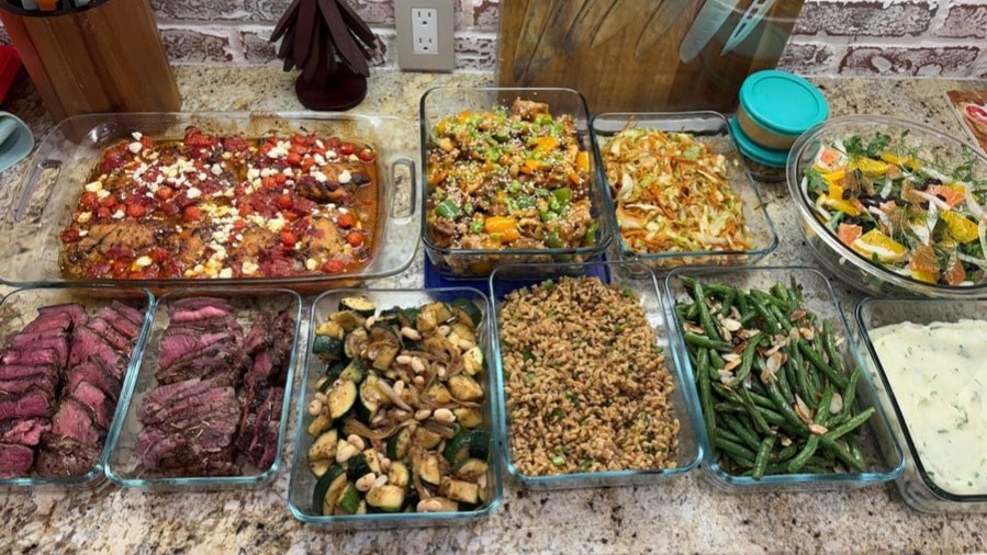 A full meal prep spread of Mediterranean and global fusion dishes.