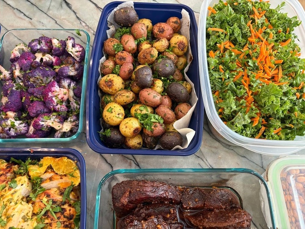 Colorful roasted potatoes, purple cauliflower, and kale salad.