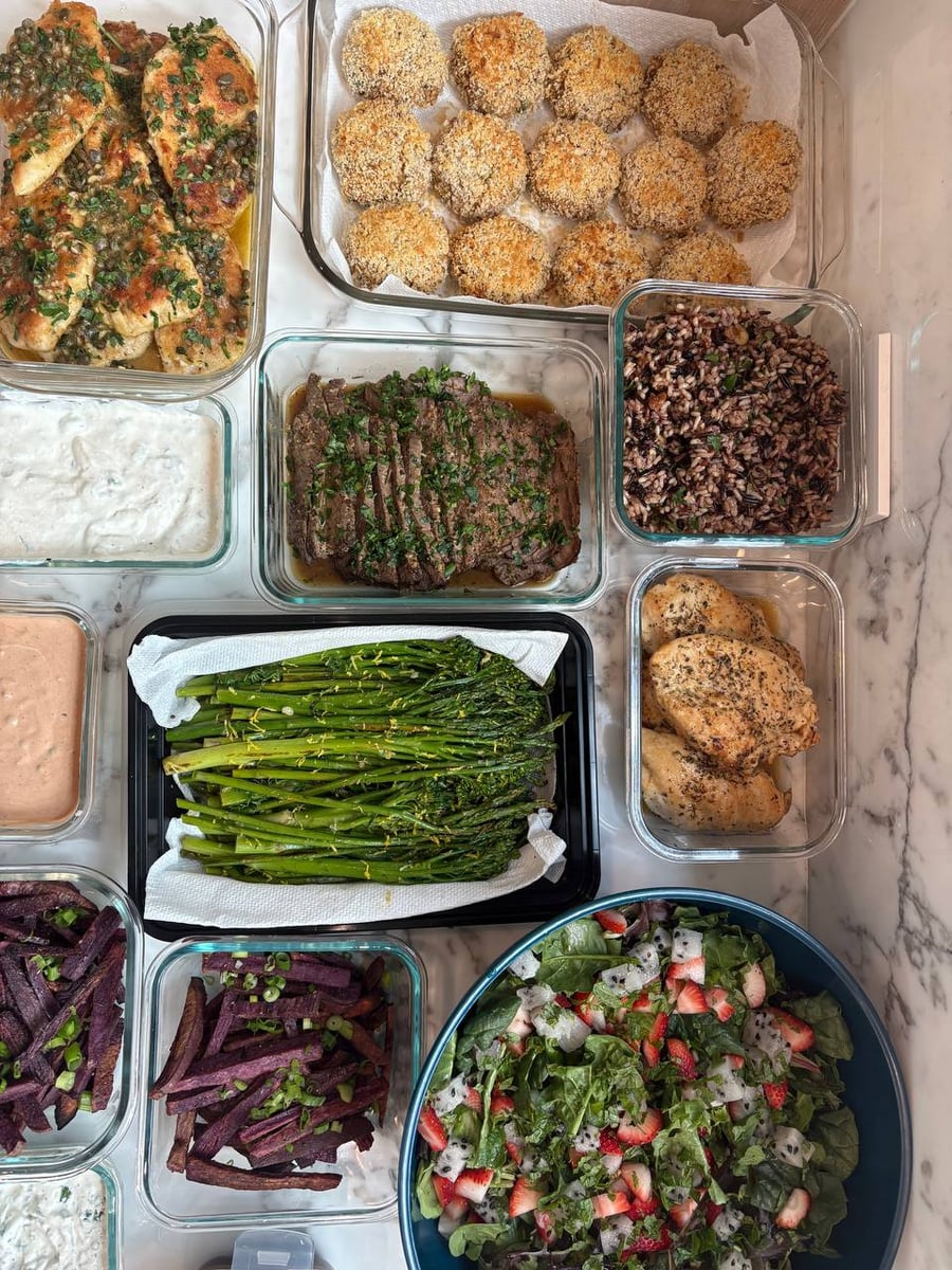 A variety of gourmet meal prep dishes including chicken piccata and purple sweet potato fries, organized for efficient refrigerator storage in Houston homes.
