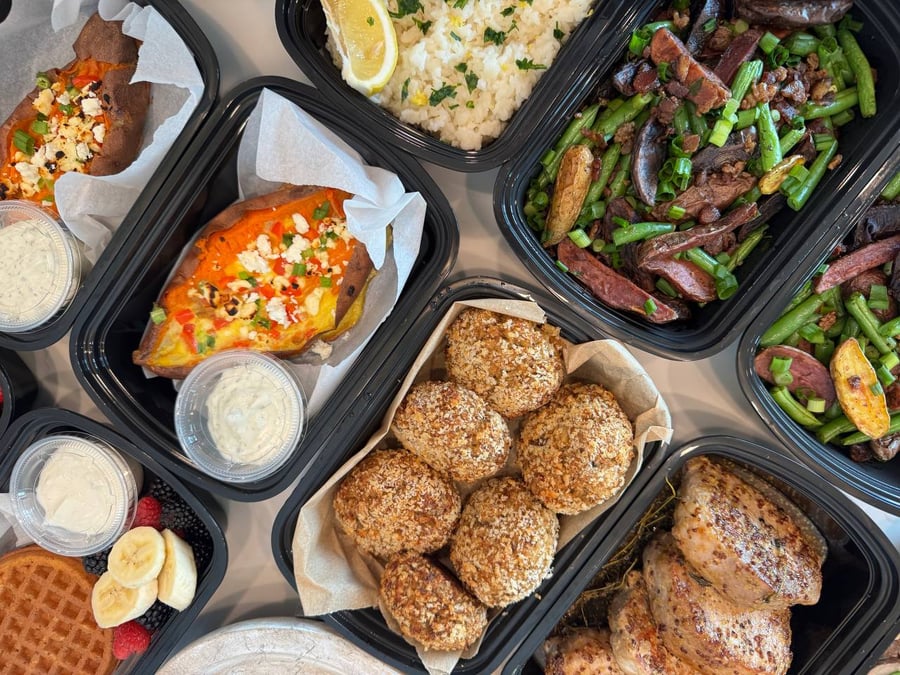 A complete spread showing scrambled egg-stuffed sweet potatoes, crab cakes, honey glazed pork chops, and classic bacon-dill green beans.