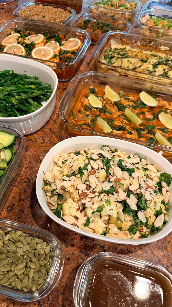 A collection of gourmet glass dishes featuring harissa baked cod with citrus, Mediterranean spiced cauliflower with toasted almonds, and a bubbly potato zucchini gratin.