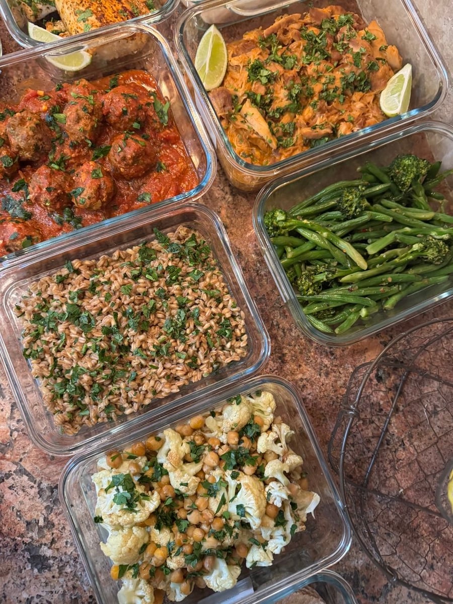 Glass containers filled with saucy shredded chicken, Tuscan meatballs, blackened mahi mahi, herbed farro, chili crisp green beans and spice-roasted cauliflower with chickpeas.