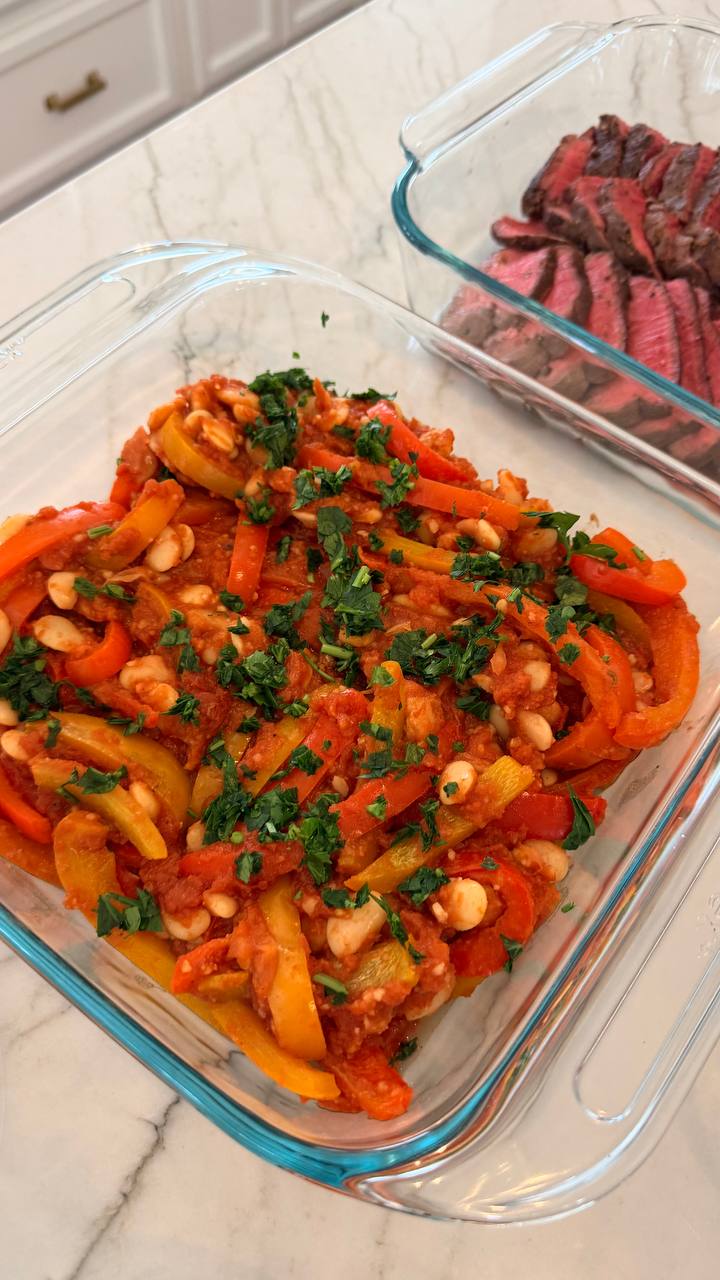 Glass meal prep containers filled with sliced medium-rare filet mignon and a savory mixture of harissa-spiced bell peppers with creamy white butter beans.