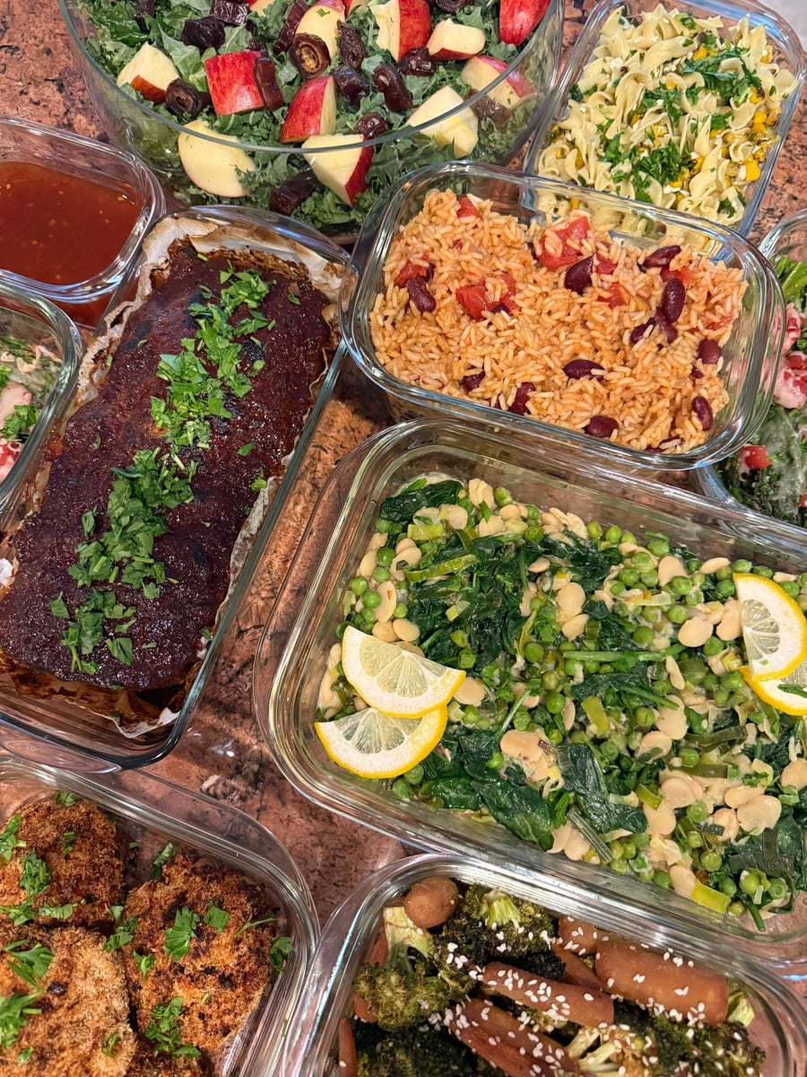 Apple wedges and dates sit on chopped kale above the meatloaf and a tray of Spanish rice.