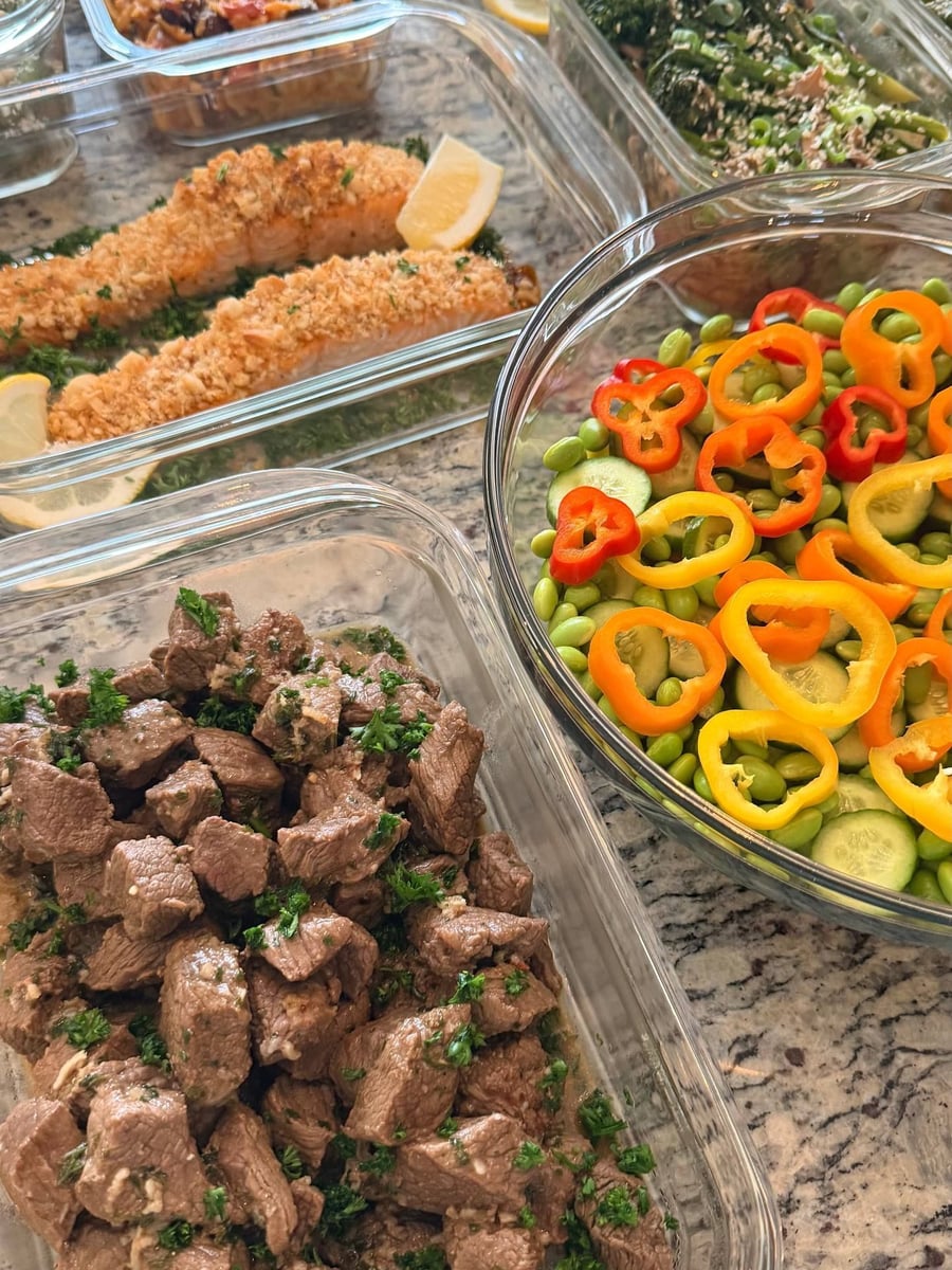 Parsley works through the cajun butter steak bites, an edamame and pepper bowl filling the right.