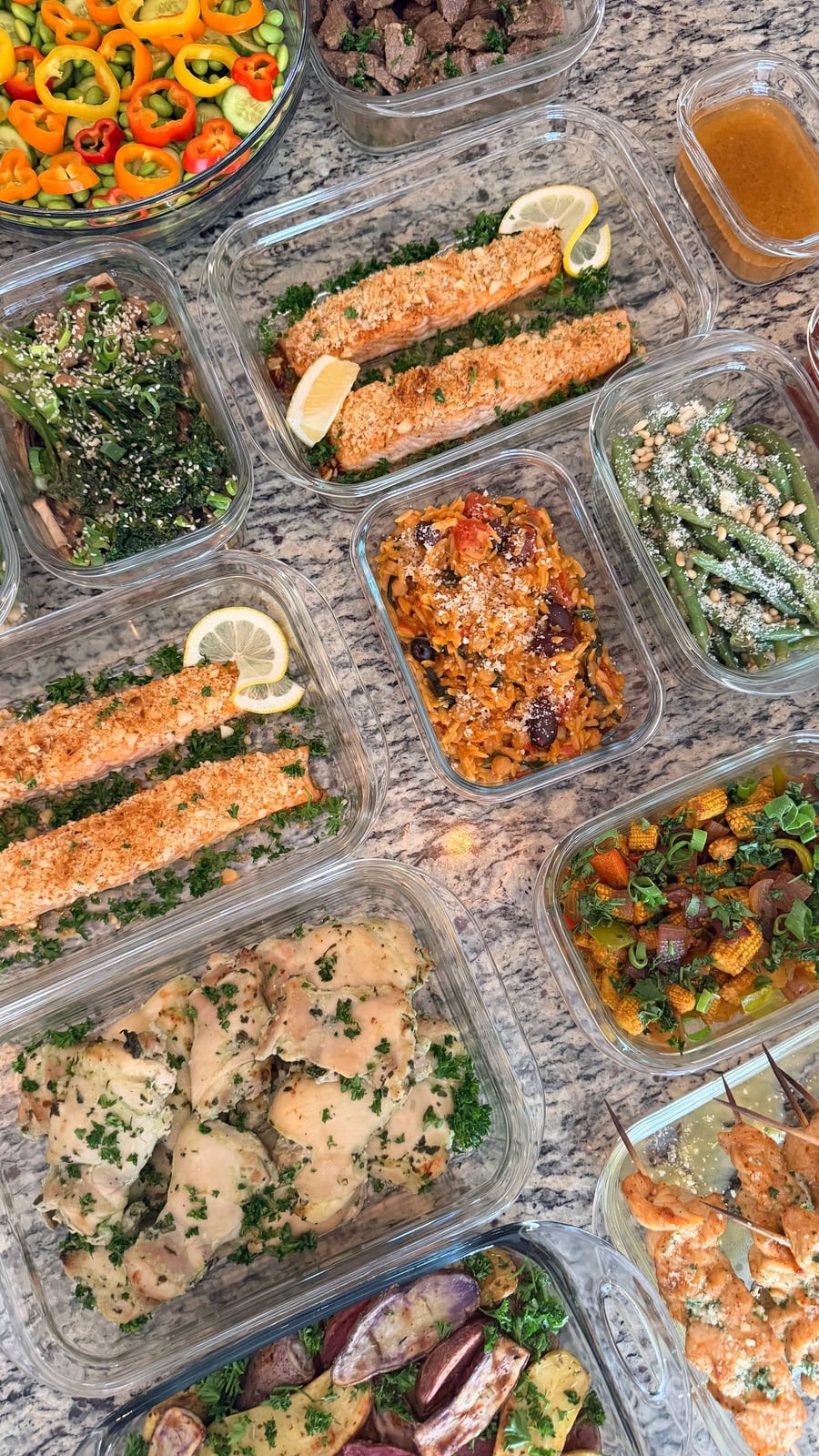 Purple and gold fingerling potatoes lie halved among herbs, skewers and salmon around the edge.
