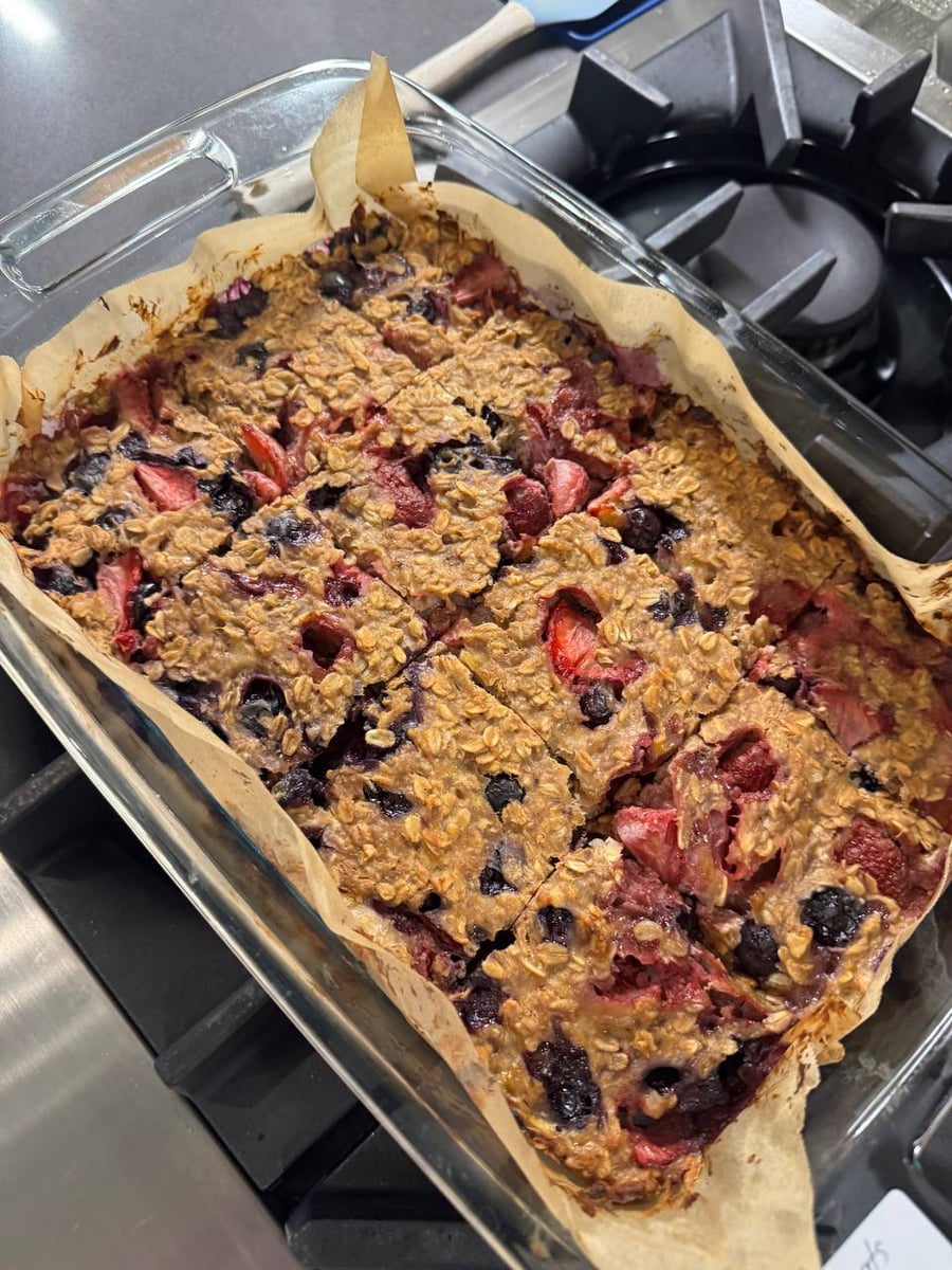 Strawberries and blueberries bake into the oat bars, cut into squares on their own parchment.