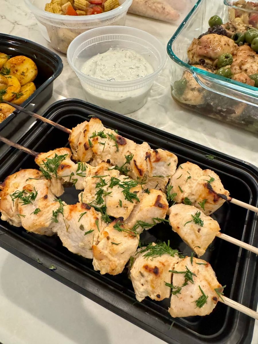 Chopped dill clings to the charred greek chicken skewers, tzatziki waiting in its tub just behind.