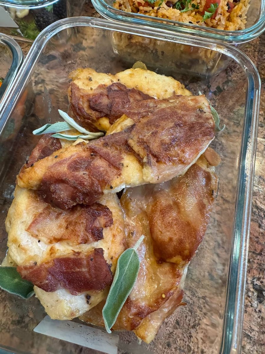 Crisped prosciutto blankets Italian chicken saltimbocca, finished with whole sage leaves beside Spanish rice.