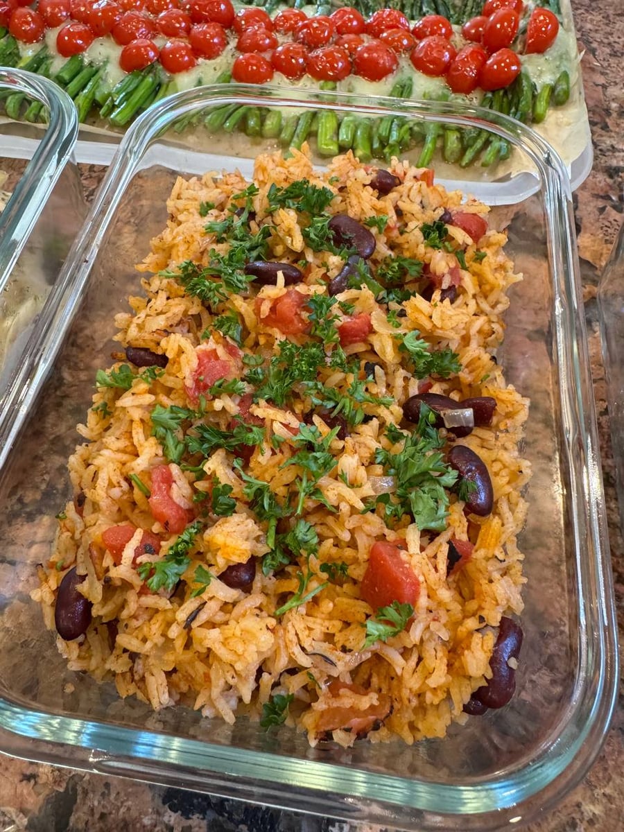 Kidney beans and diced tomatoes run through paprika-tinted Spanish rice under a generous scatter of parsley.