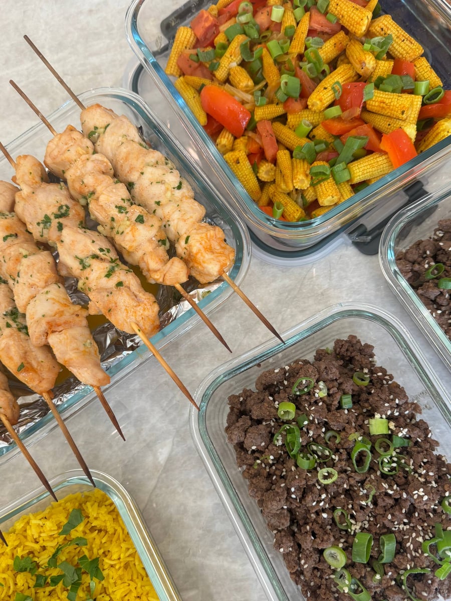 Twisted chicken skewers sit between scallion-topped Korean beef and baby corn stir fry with red peppers.