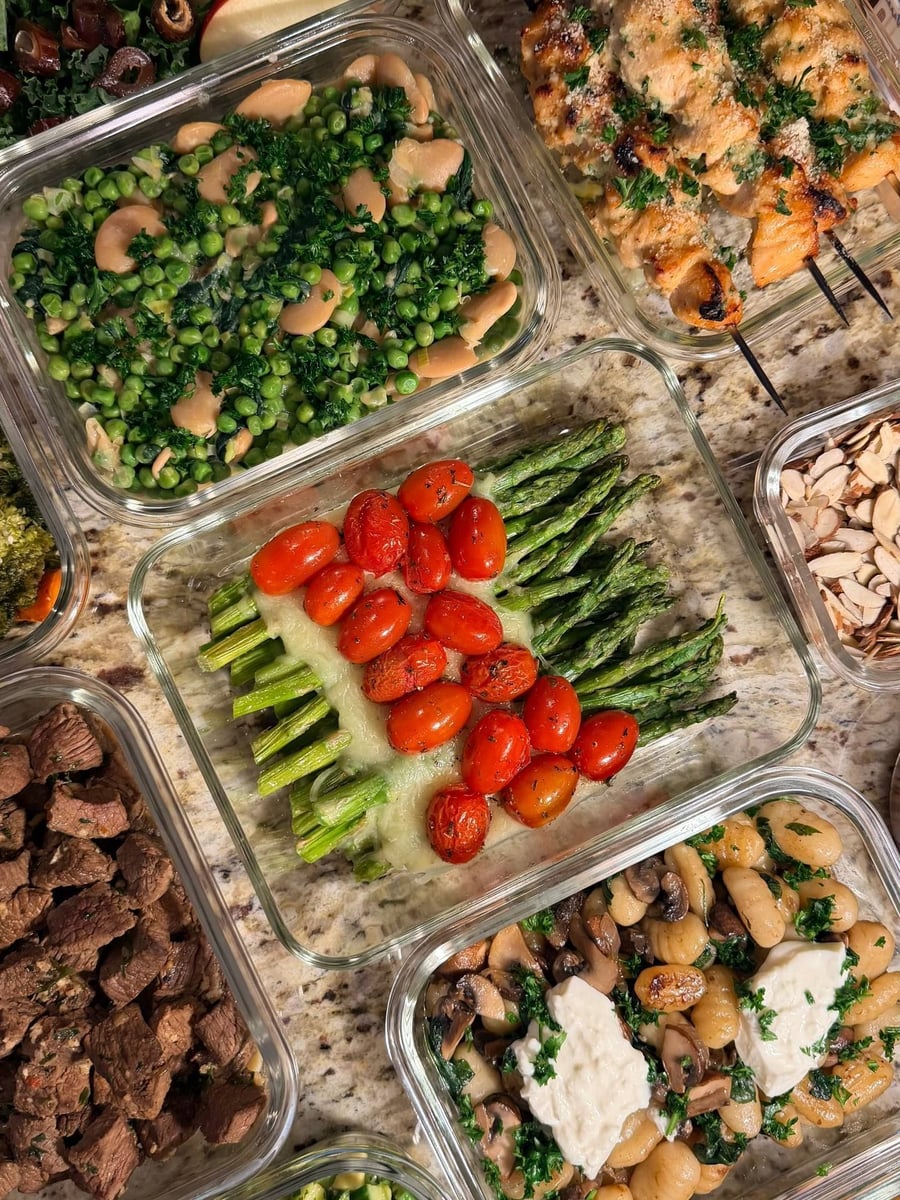 Blistered tomatoes and asparagus spears meet over melted cheese, peas and steak bites either side.