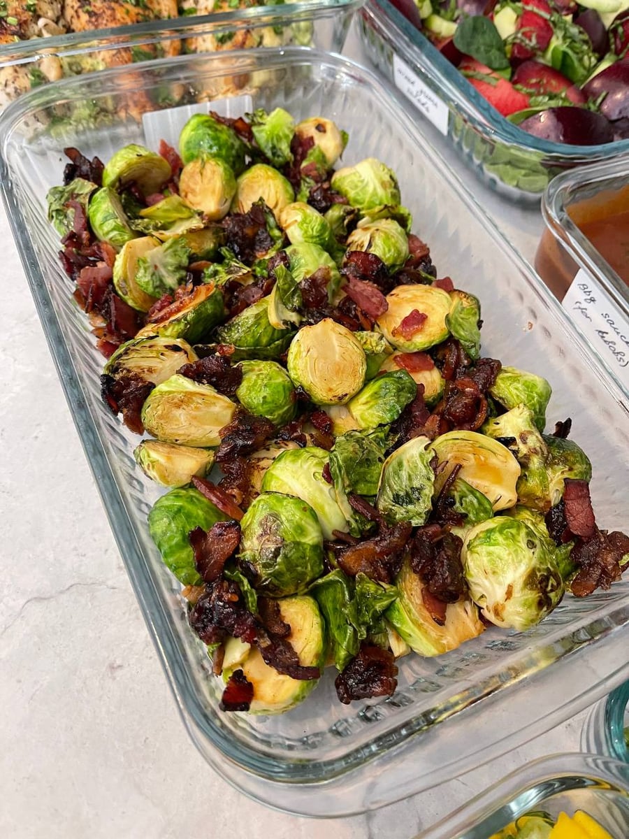 Crisped bacon threads between halved brussel sprouts, dates gone dark and sticky among them.