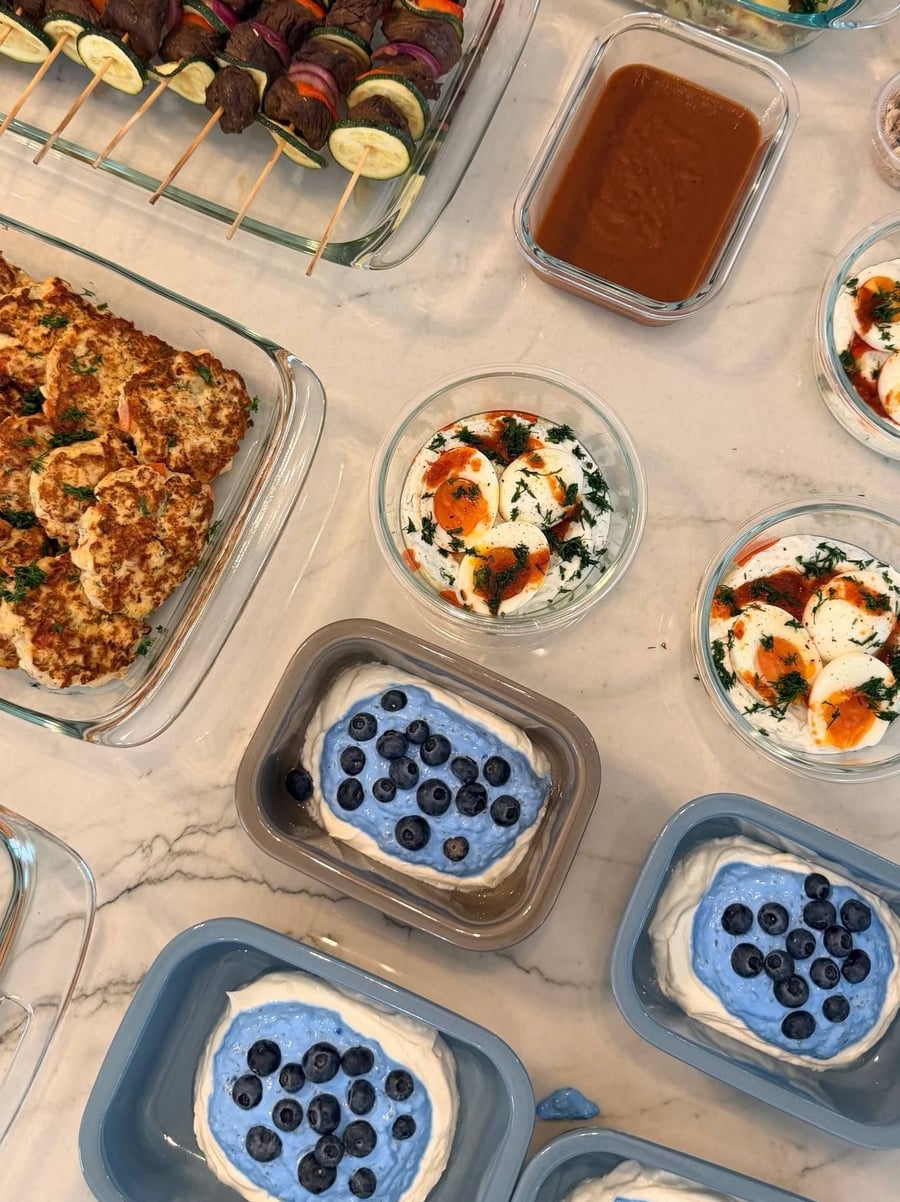 Blue spirulina layers over thick yogurt under a scatter of whole blueberries, four portions deep.