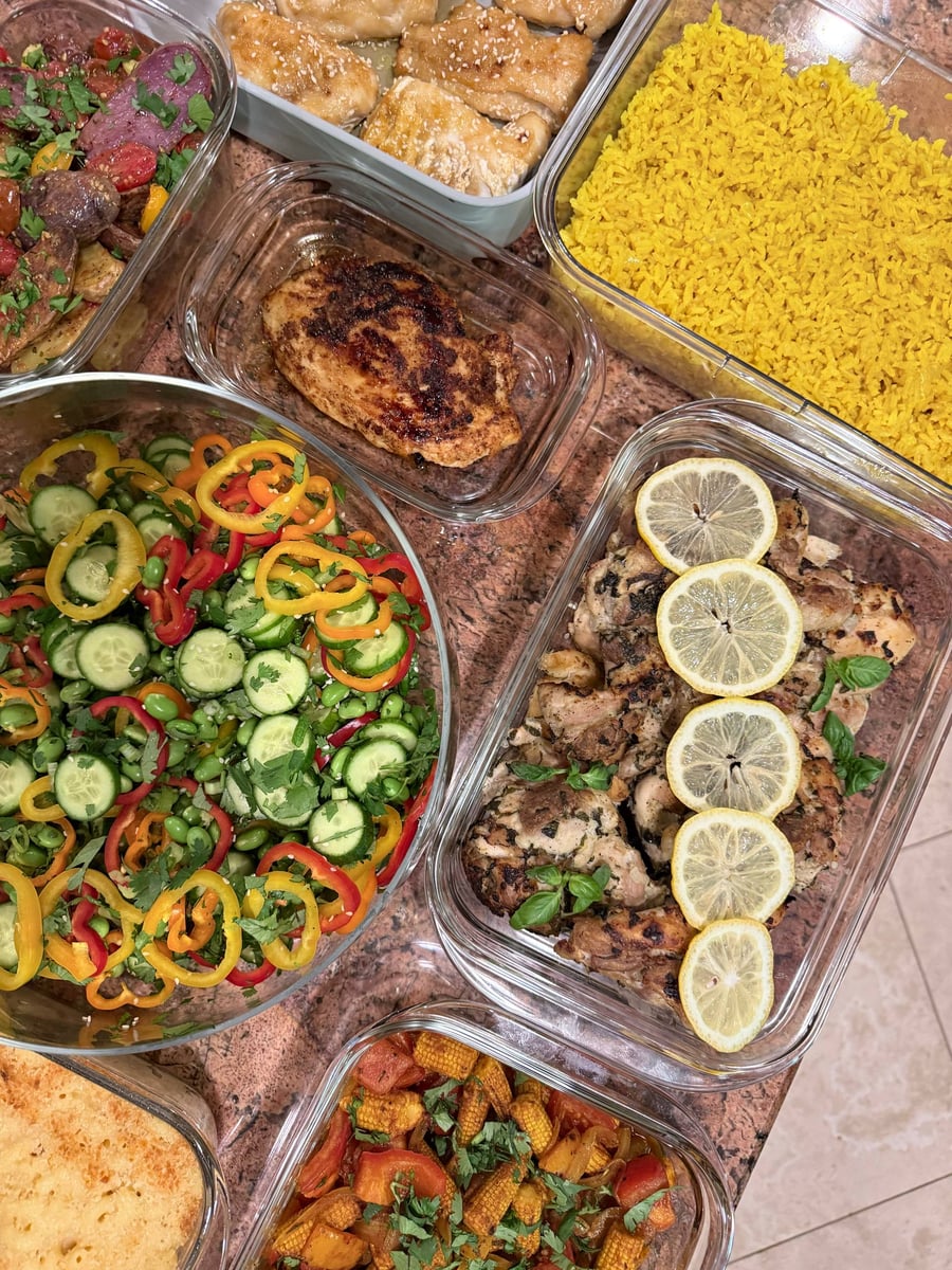Breadcrumb-topped macaroni fills the frame beside cucumber edamame salad, lemon chicken, Parmesan green beans and baby corn.