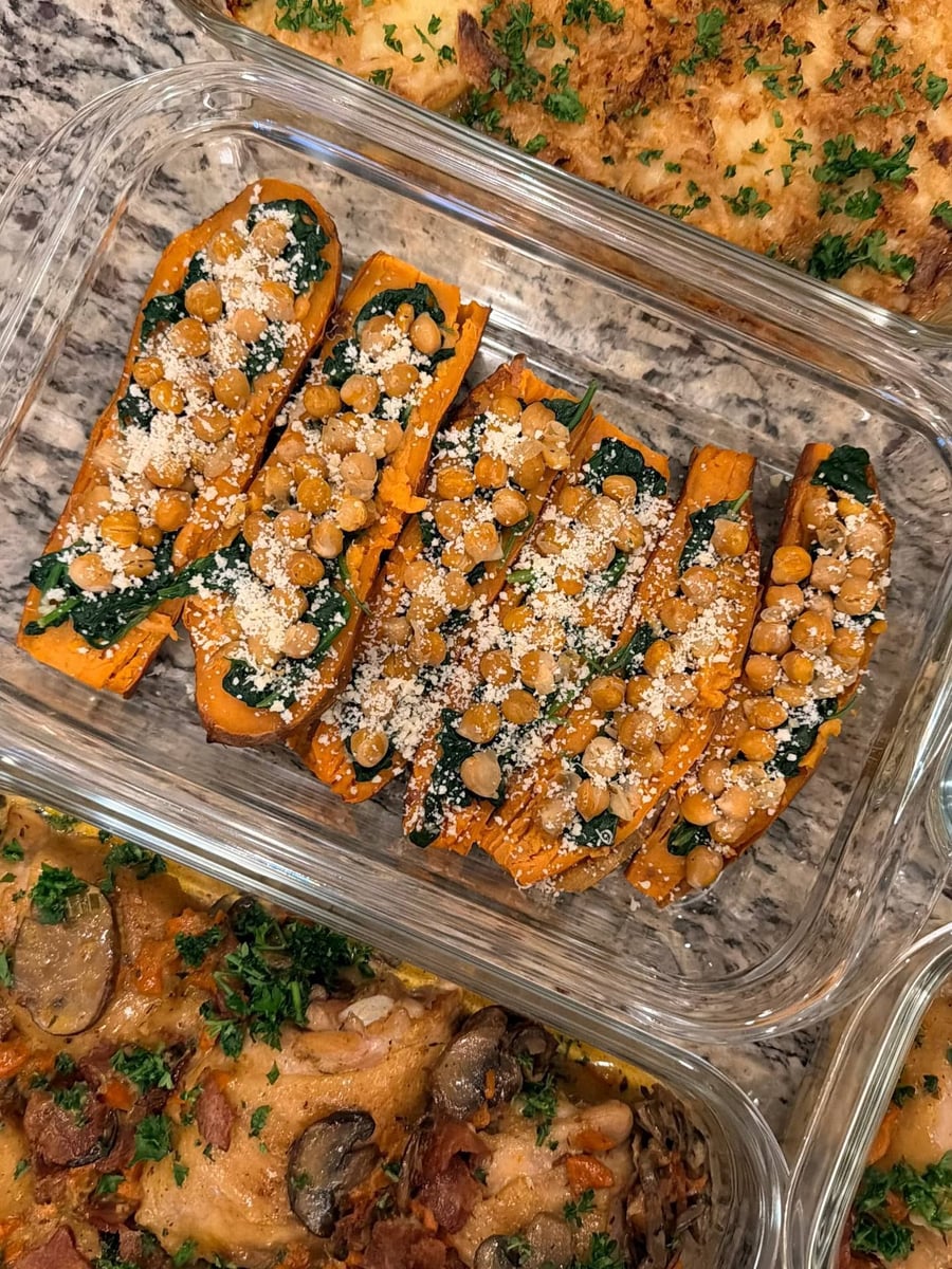 Chickpeas and wilted spinach line six sweet potato halves under a dusting of parmesan.