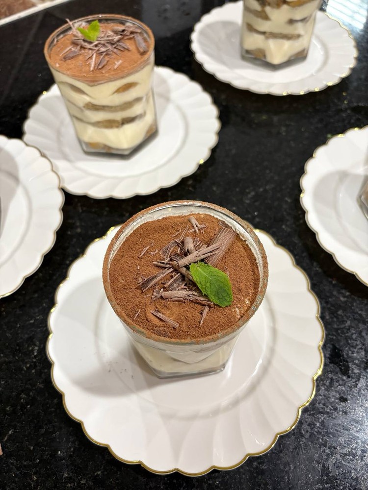 Several individual tiramisu desserts with chocolate and mint.