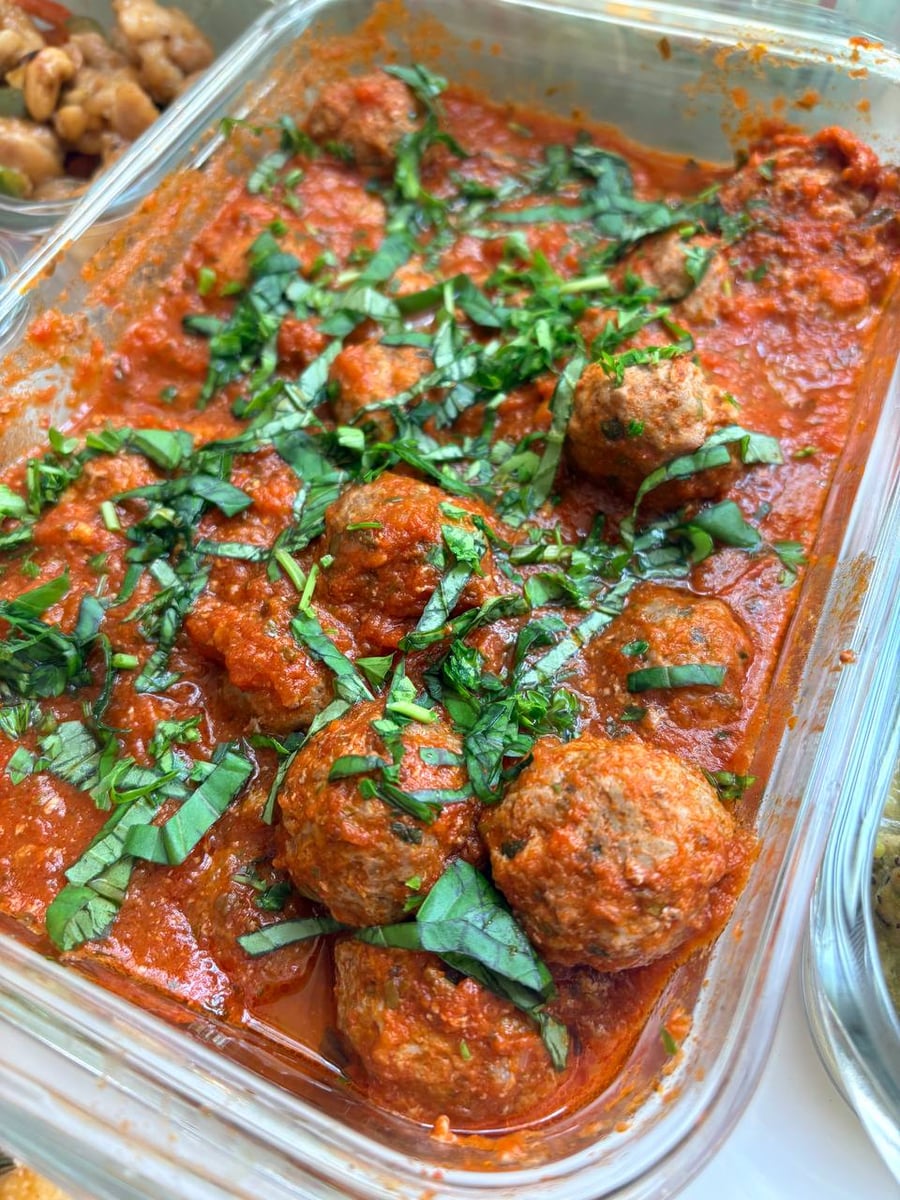 Italian meatballs and edamame salad anchor a counter of chicken skewers, broccolini, green beans, gnocchi and potatoes.