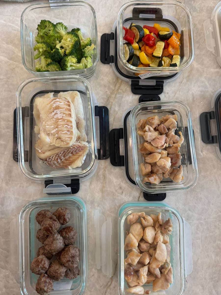 Plain cod filets, seared chicken bites and beef meatballs line up with steamed broccoli and roasted peppers.
