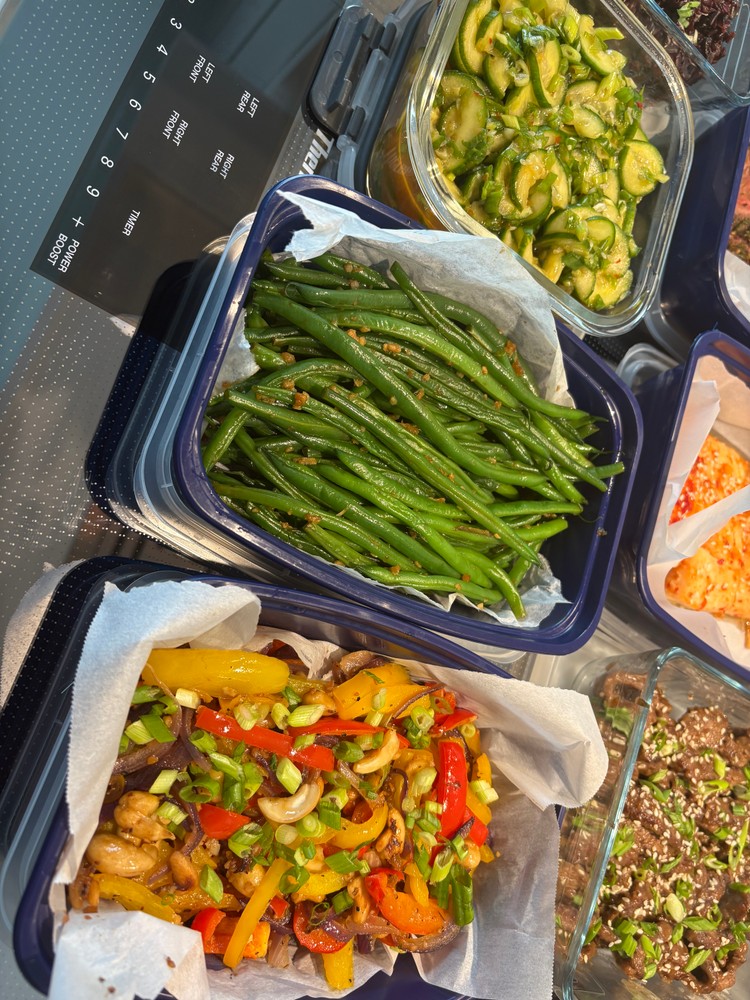 Green beans and colorful bell pepper stir-fry in meal prep containers.