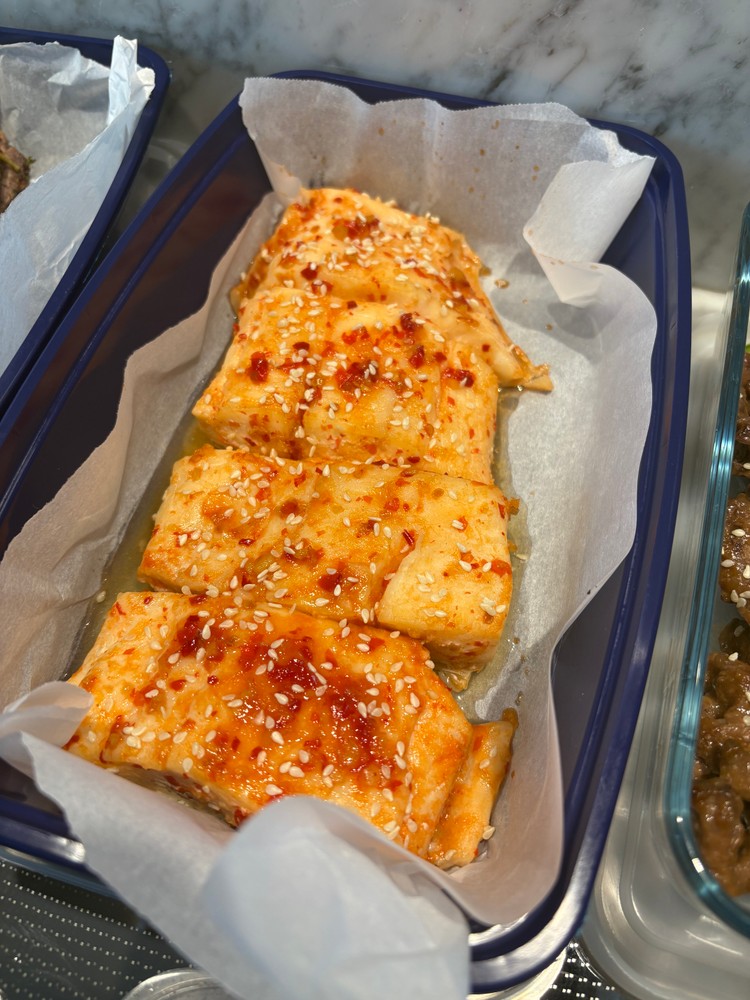 Spicy white fish fillets with chili flakes and sesame seeds.