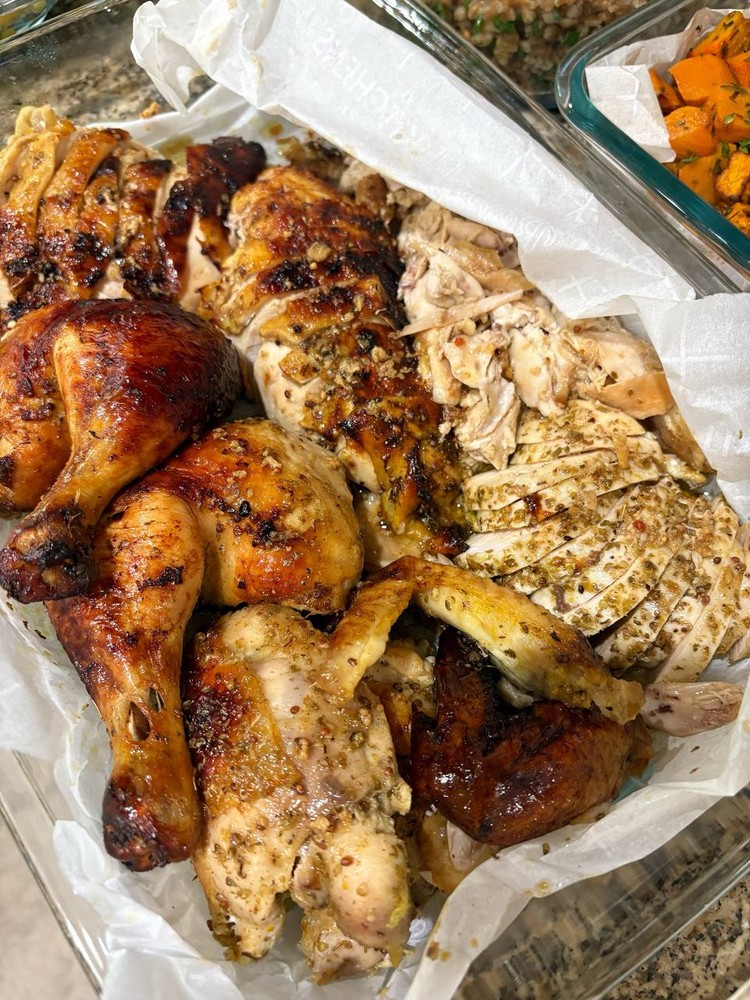 Roasted whole chicken, cut into pieces, with crispy skin and herbs.