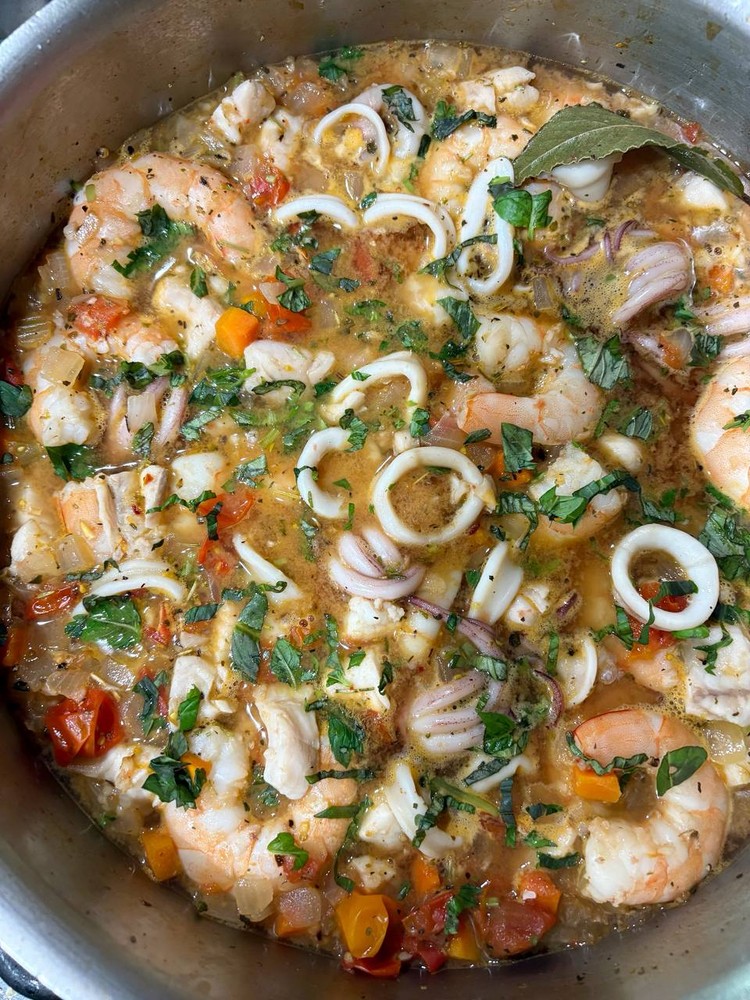 Close-up of seafood medley with shrimp, calamari, and vegetables.