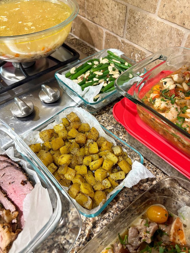 Roasted diced potatoes and green beans with almonds in glass containers.