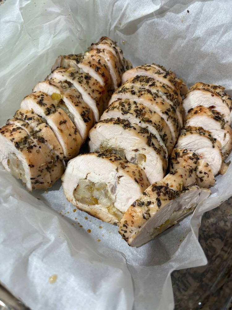Sliced herb-crusted stuffed chicken breast on parchment paper