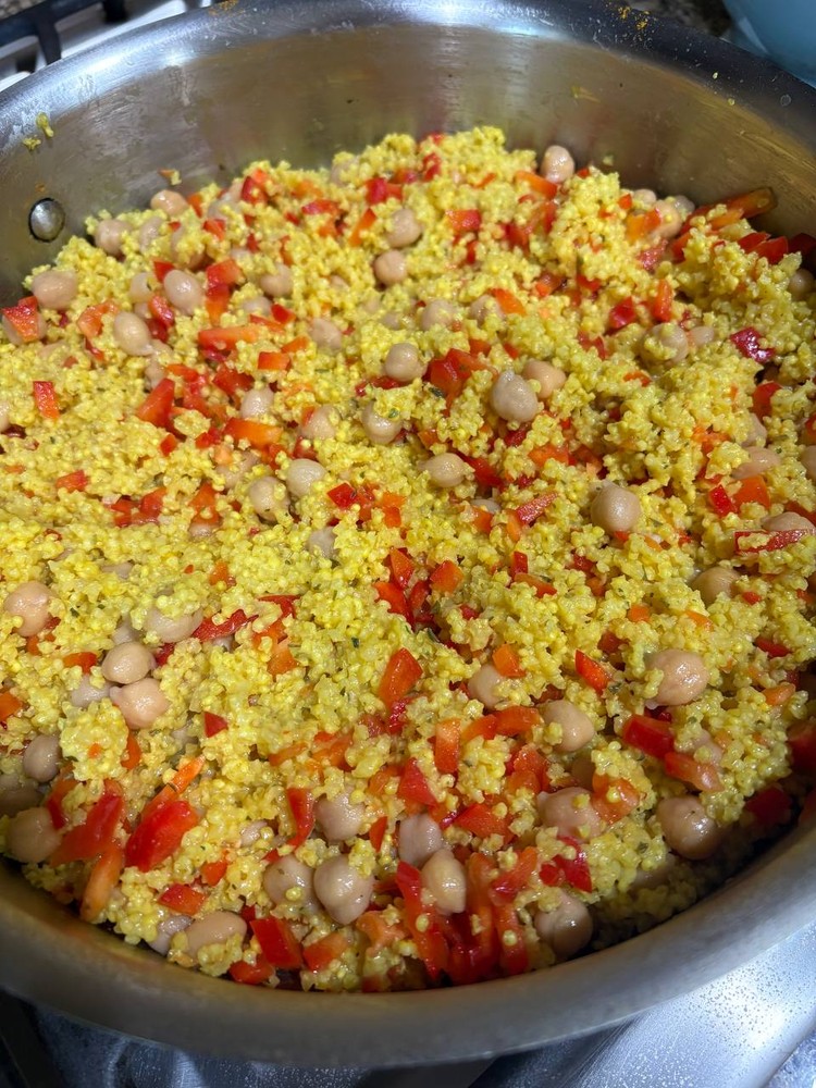 Millet with chickpeas and diced red peppers in a pan