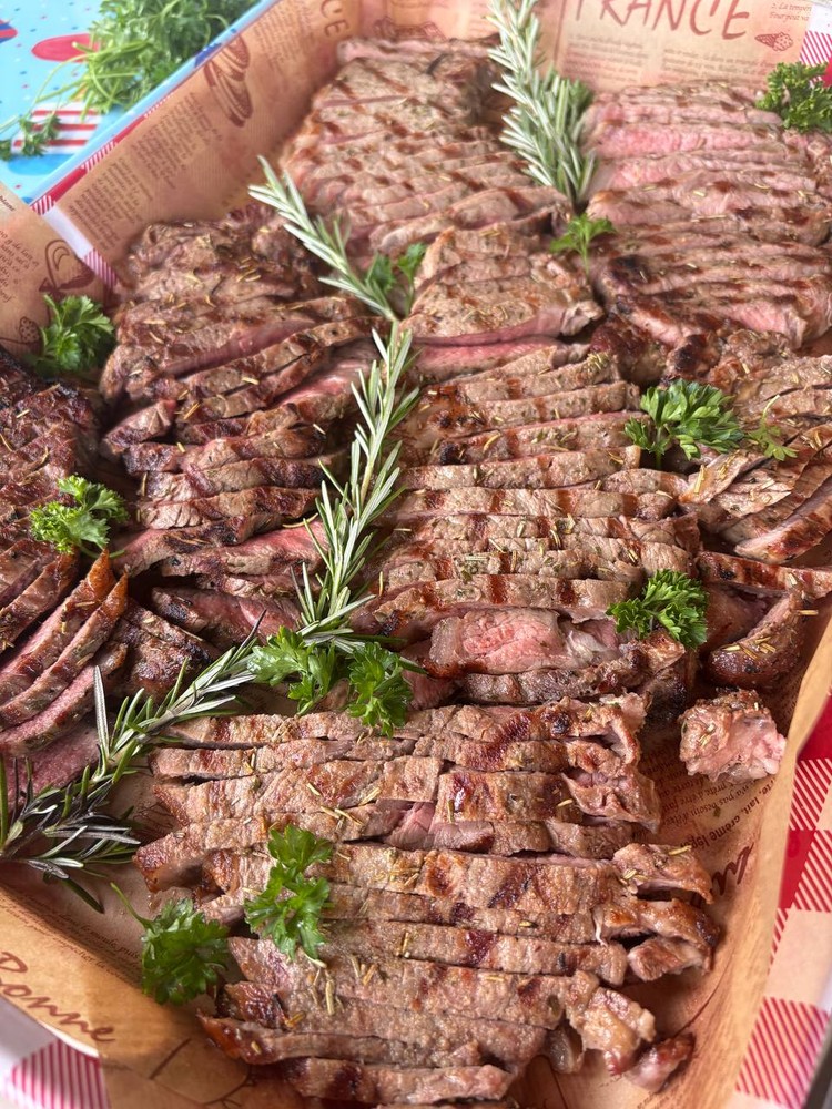 Sliced rosemary and oregano grilled prime New York strip steaks.