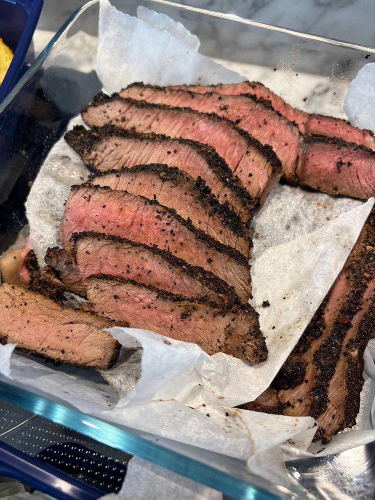 Perfectly sliced medium-rare steak with a pepper crust.