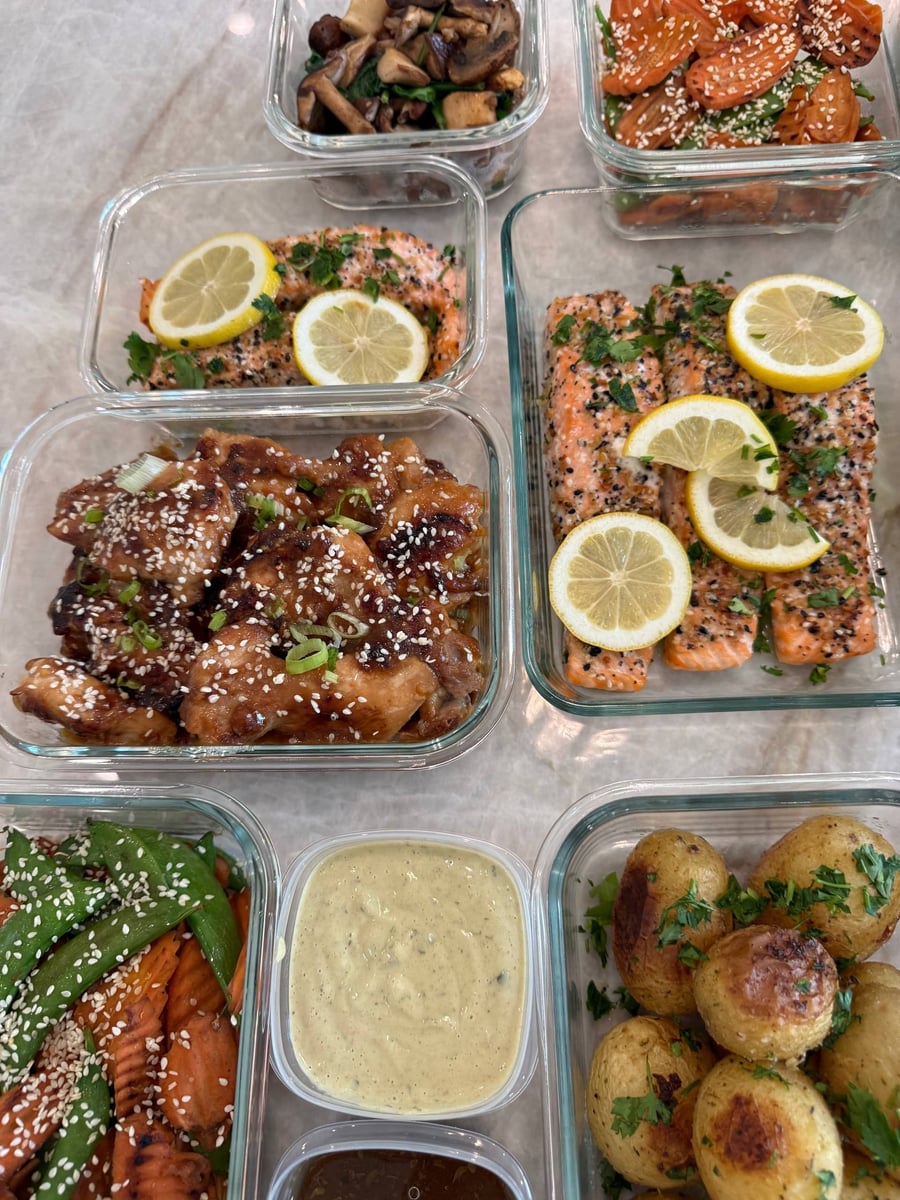 Salmon fillets wear a black and white seed crust, lemon wheels laid across and parsley scattered over.