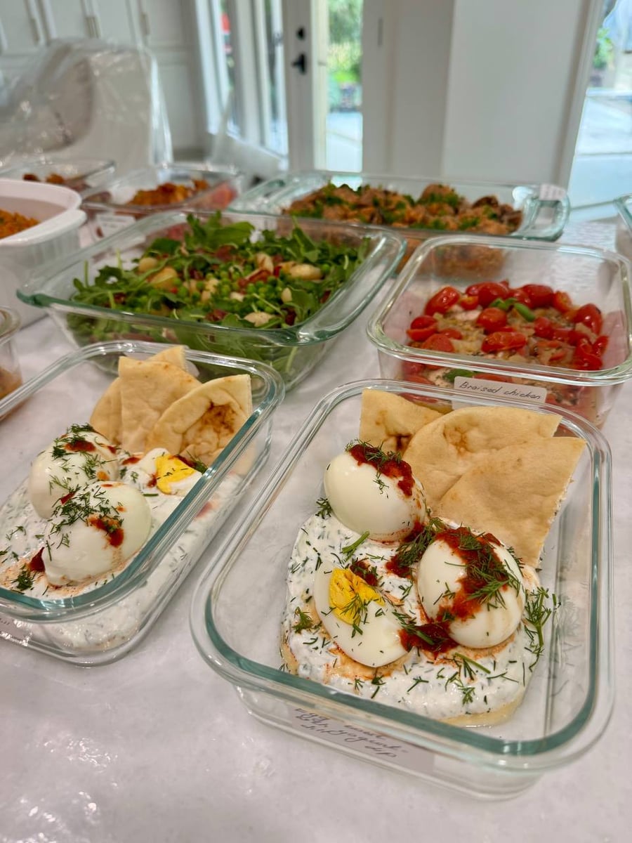 Soft boiled eggs rest on dill yogurt streaked with chili oil, garlic naan wedged alongside.