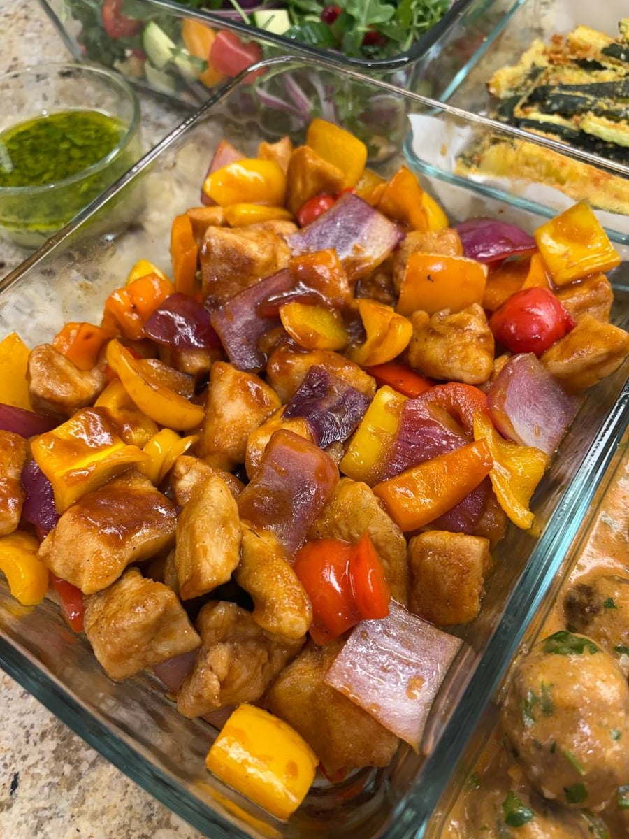 Glazed chicken bites tumble with yellow and red bell peppers, charred red onion through the middle.