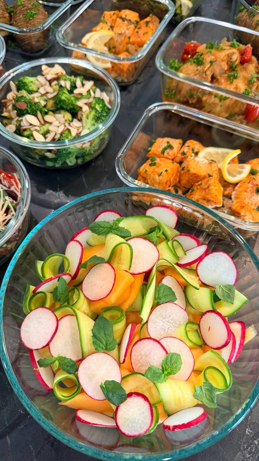 Cantaloupe wedges, cucumber ribbons and thin radish rounds layered with mint leaves in a wide bowl.
