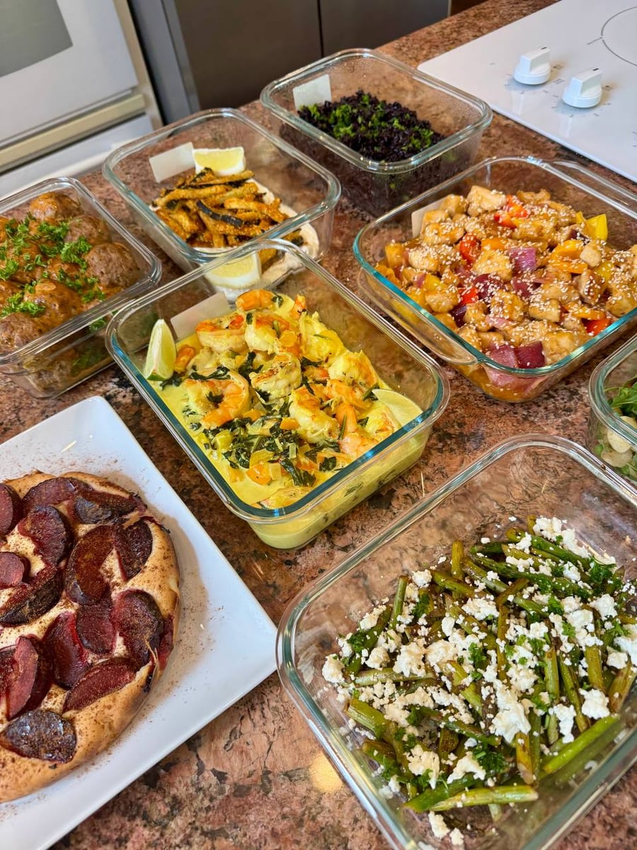 Plum loaf on a white plate sits below coconut shrimp, purple rice and feta-strewn asparagus.