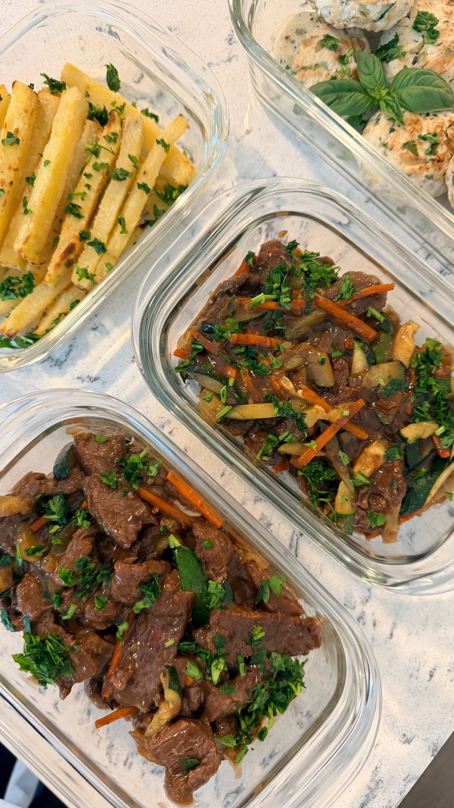 Carrot matchsticks and zucchini thread through the glossy bison stir fry, potato fries filling the tray at left.
